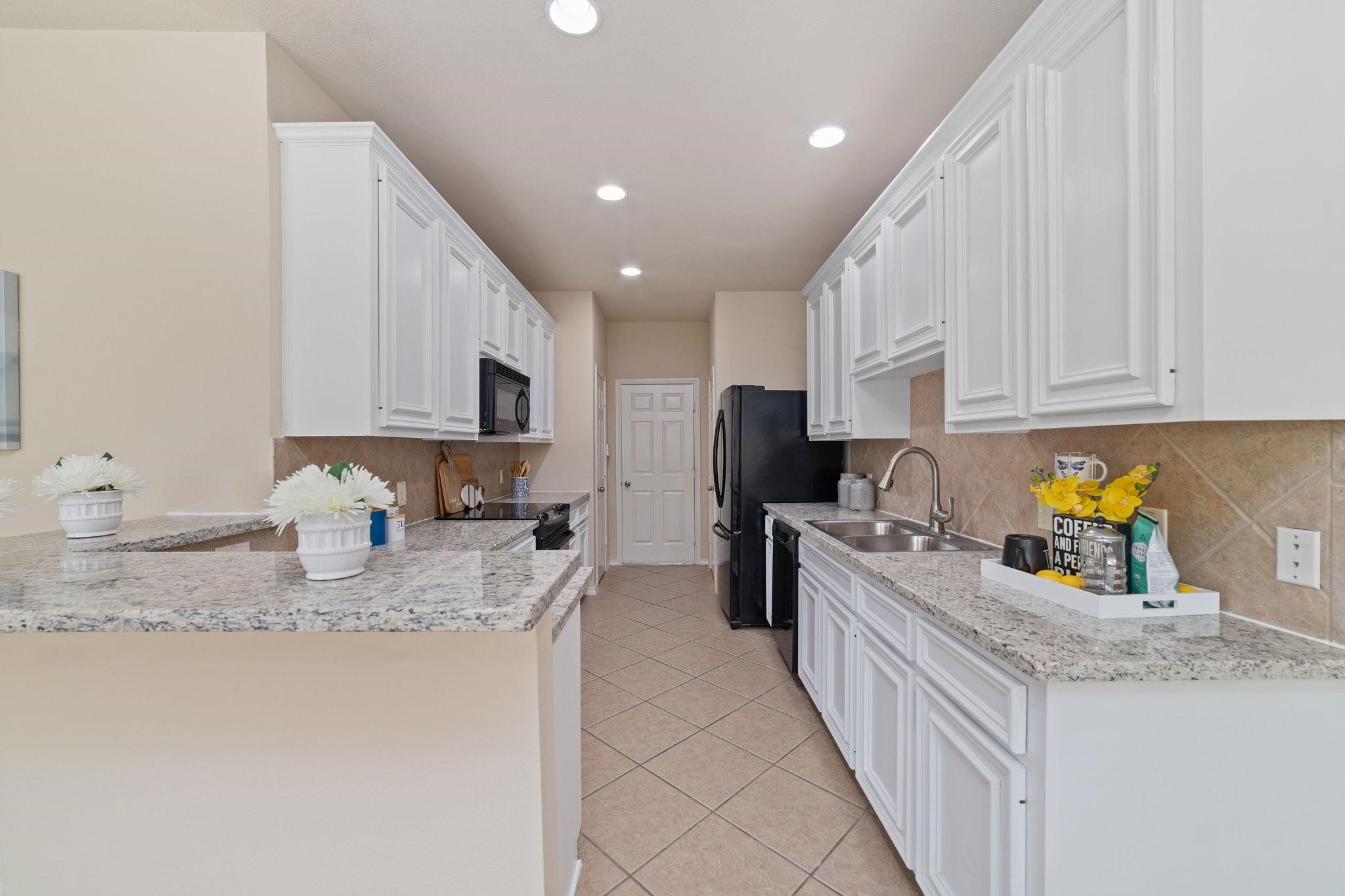 14923 Tuttle Point Drive Houston, TX 77082 - Photo 10 of 24 a kitchen with stainless steel appliances granite countertop a sink stove and refrigerator