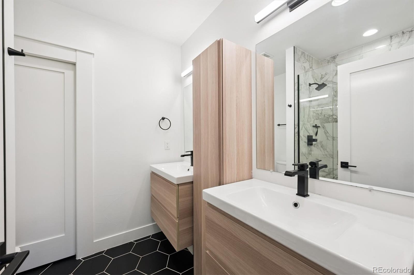 3124 Gilpin Street Denver, CO 80205 - Photo 15 of 46 a bathroom with a sink a mirror and a shower