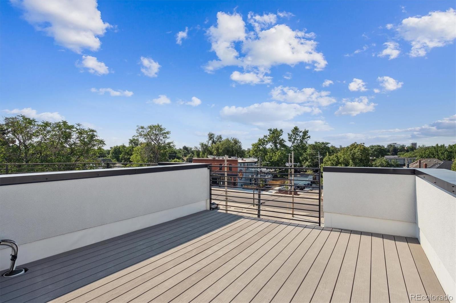 3124 Gilpin Street Denver, CO 80205 - Photo 22 of 46 a view of a balcony with wooden floor and iron fence