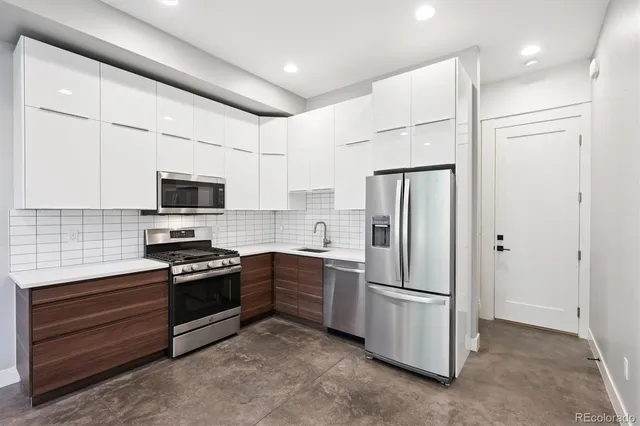 a kitchen with stainless steel appliances a refrigerator sink and stove top oven