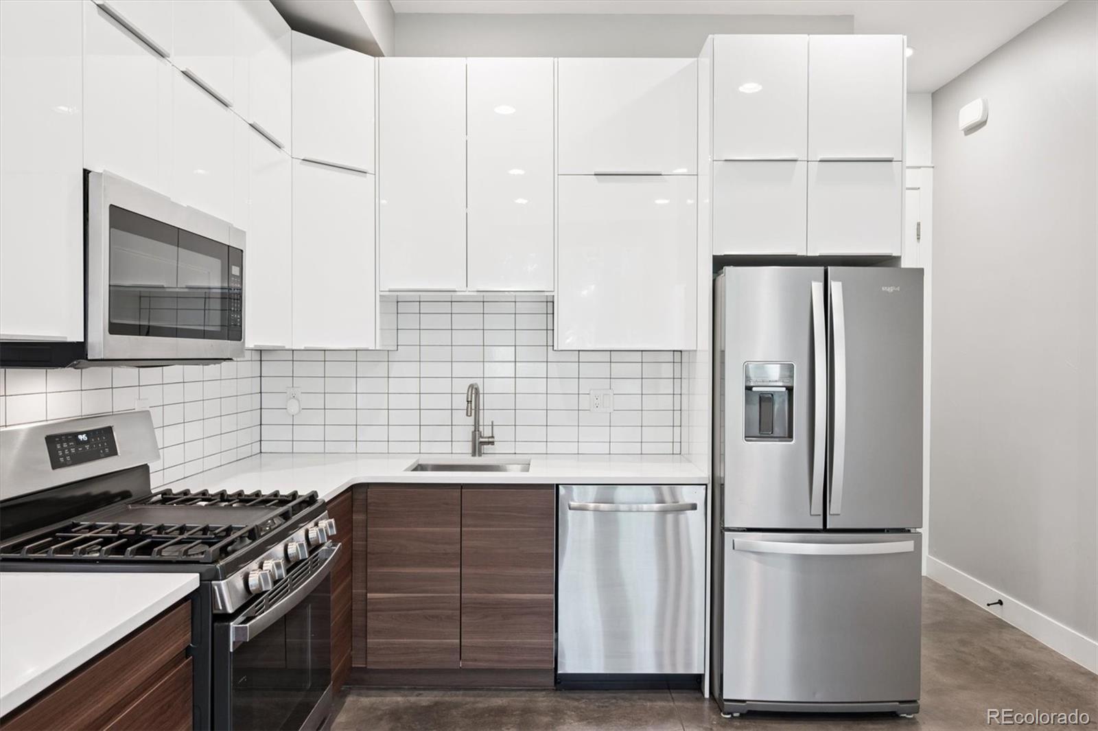 3124 Gilpin Street Denver, CO 80205 - Photo 6 of 46 a kitchen with stainless steel appliances a refrigerator stove and microwave
