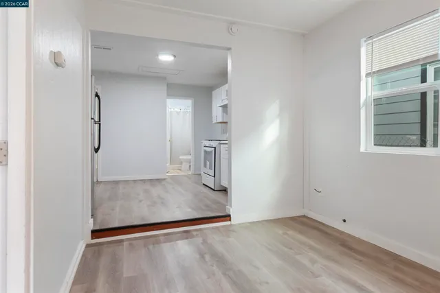 a view of empty room with wooden floor and window