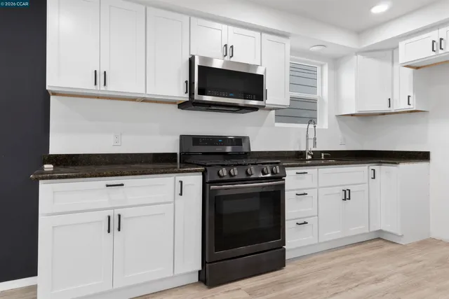 a kitchen with stainless steel appliances granite countertop a stove a microwave and oven