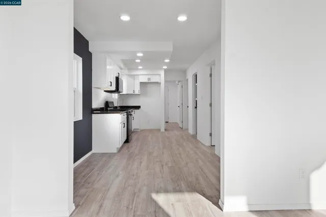 a kitchen with granite countertop a sink stove and refrigerator