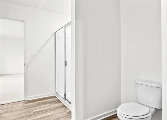 a white toilet sitting next to a shower