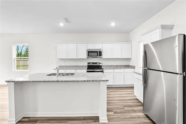 a kitchen with granite countertop cabinets and refrigerator