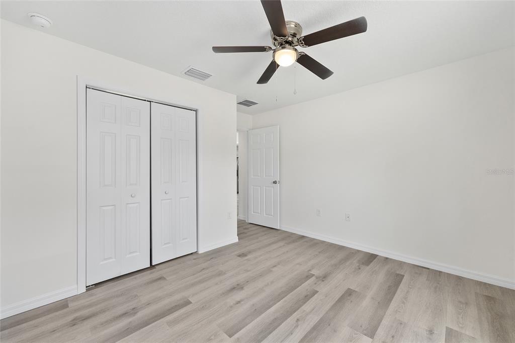 13019 Northeast 7th Loop Silver Springs, FL 34488 - Photo 30 of 35 an empty room with wooden floor fan and windows
