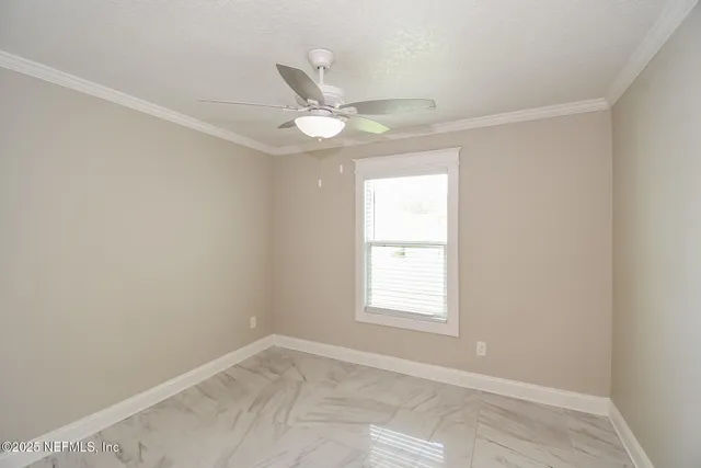 an empty room with windows and fan