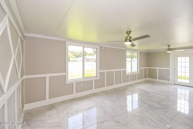 an empty room with windows and chandelier