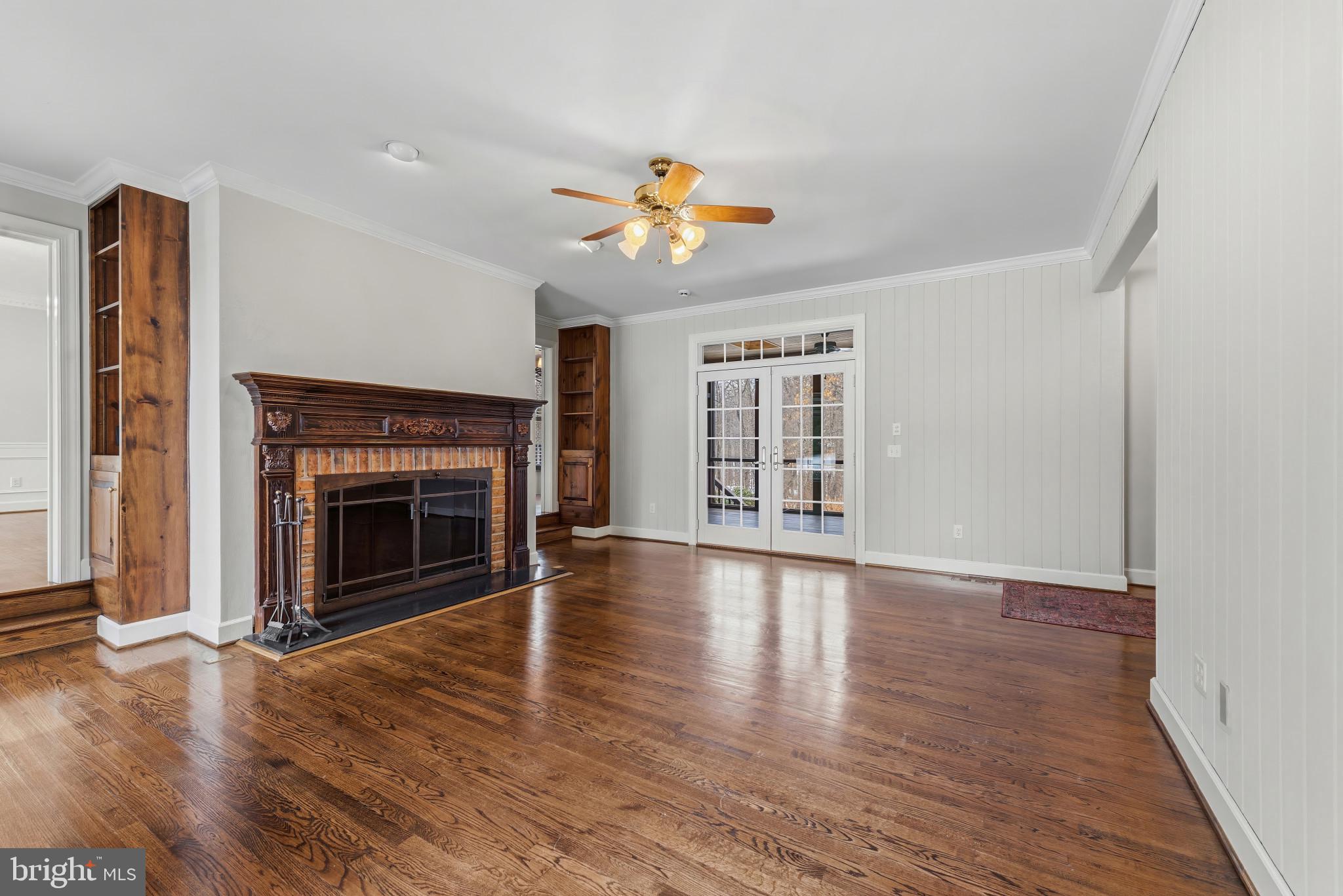 14002 Fox Run Court Phoenix, MD 21131 - Photo 11 of 64 an empty room with windows fireplace and a kitchen view