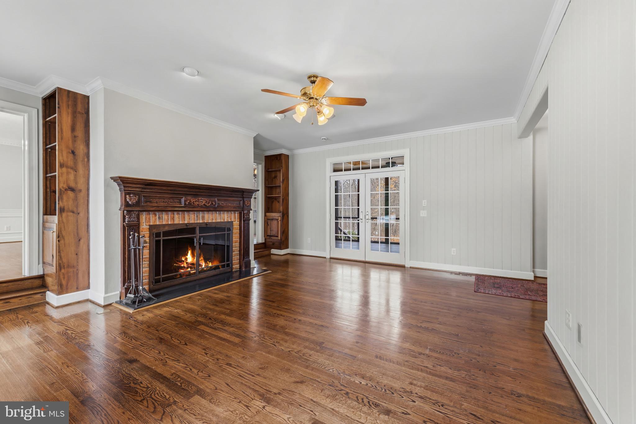 14002 Fox Run Court Phoenix, MD 21131 - Photo 12 of 64 an empty room with windows fireplace and wooden floor