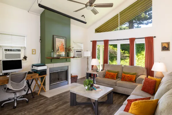 a living room with furniture a flat screen tv and a floor to ceiling window