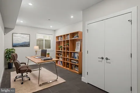 a view of a workspace with furniture and a window