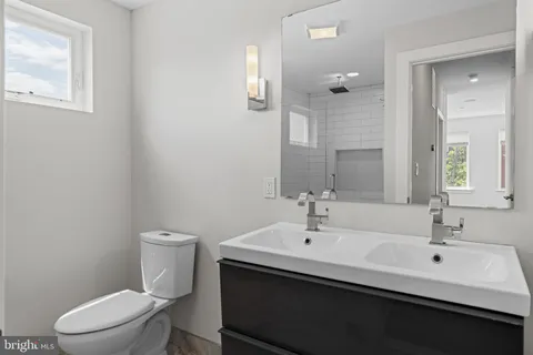 a bathroom with a sink mirror and toilet