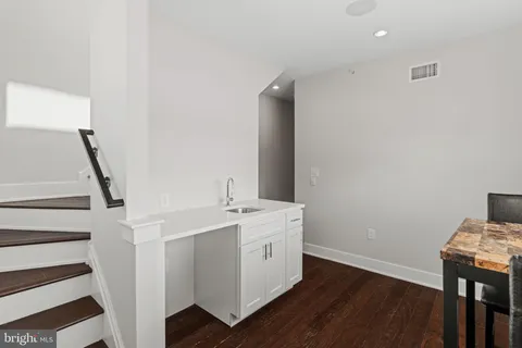 a utility room with wooden floor washer and dryer