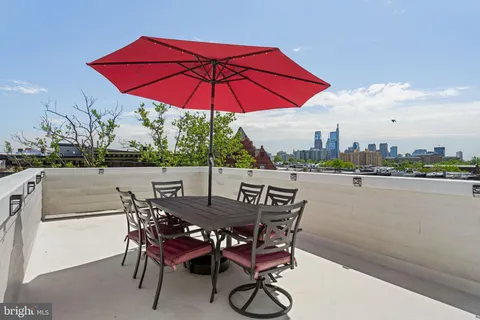 a view of a terrace with furniture and umbrella