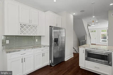 a kitchen with cabinets stainless steel appliances and wooden floor