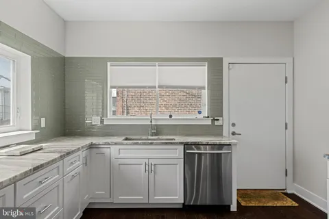 a kitchen with stainless steel appliances granite countertop a sink and a window