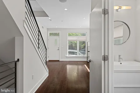 a view of a hallway with wooden floor and entryway
