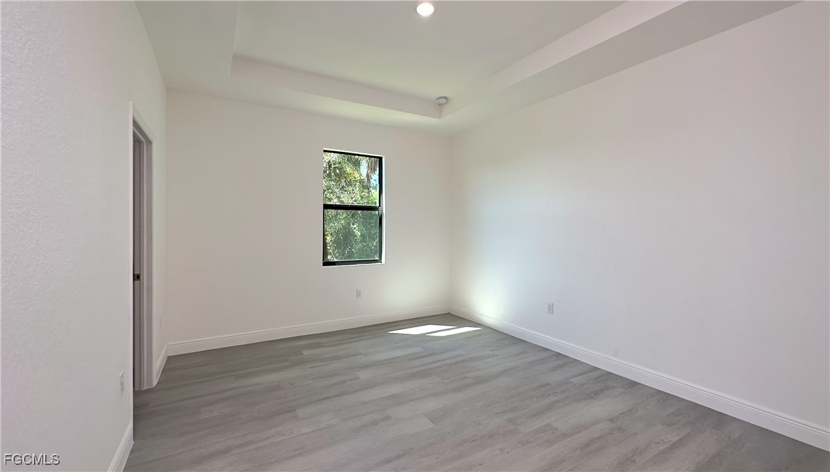 5018 Quebec Road LaBelle, FL 33935 - Photo 5 of 9 an empty room with wooden floor and windows