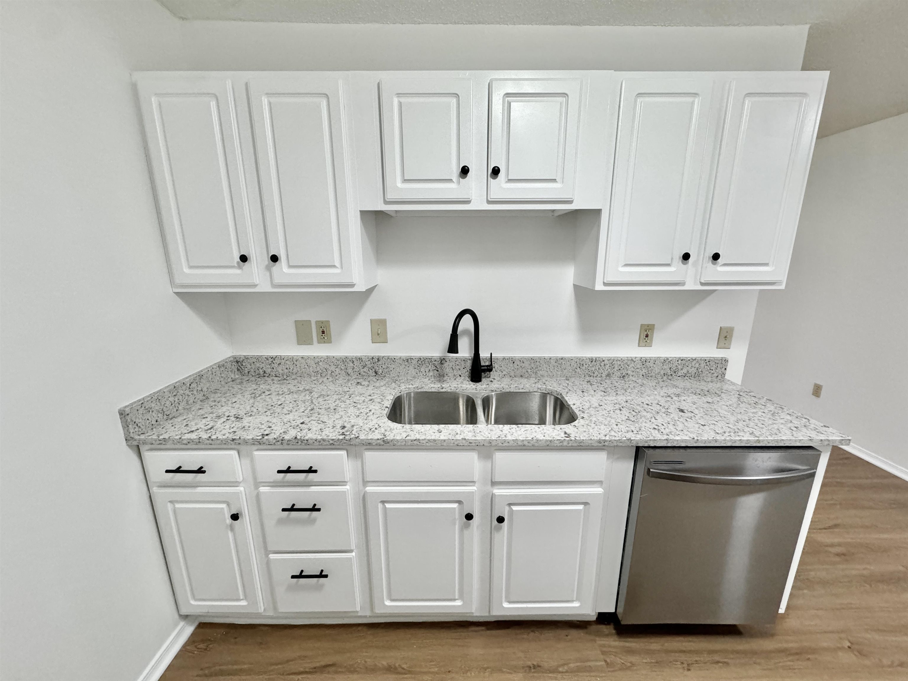 520 Stone Road Pinson, TN 38366 - Photo 4 of 30 Kitchen featuring stainless steel dishwasher, a sink, white cabinetry, and wood finished floors
