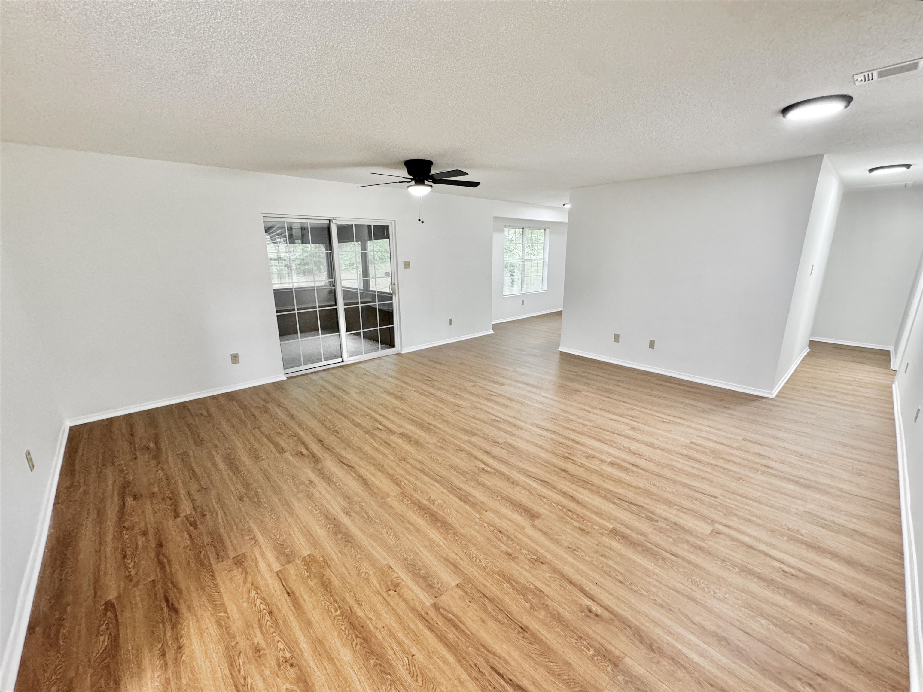 520 Stone Road Pinson, TN 38366 - Photo 7 of 30 Unfurnished living room with a textured ceiling, light wood-style floors, a ceiling fan, and visible vents