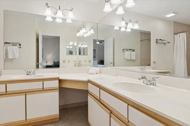 a spacious bathroom with a sink double vanity granite and a shower