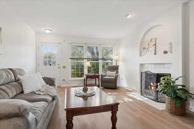a living room with furniture a fireplace and a large window
