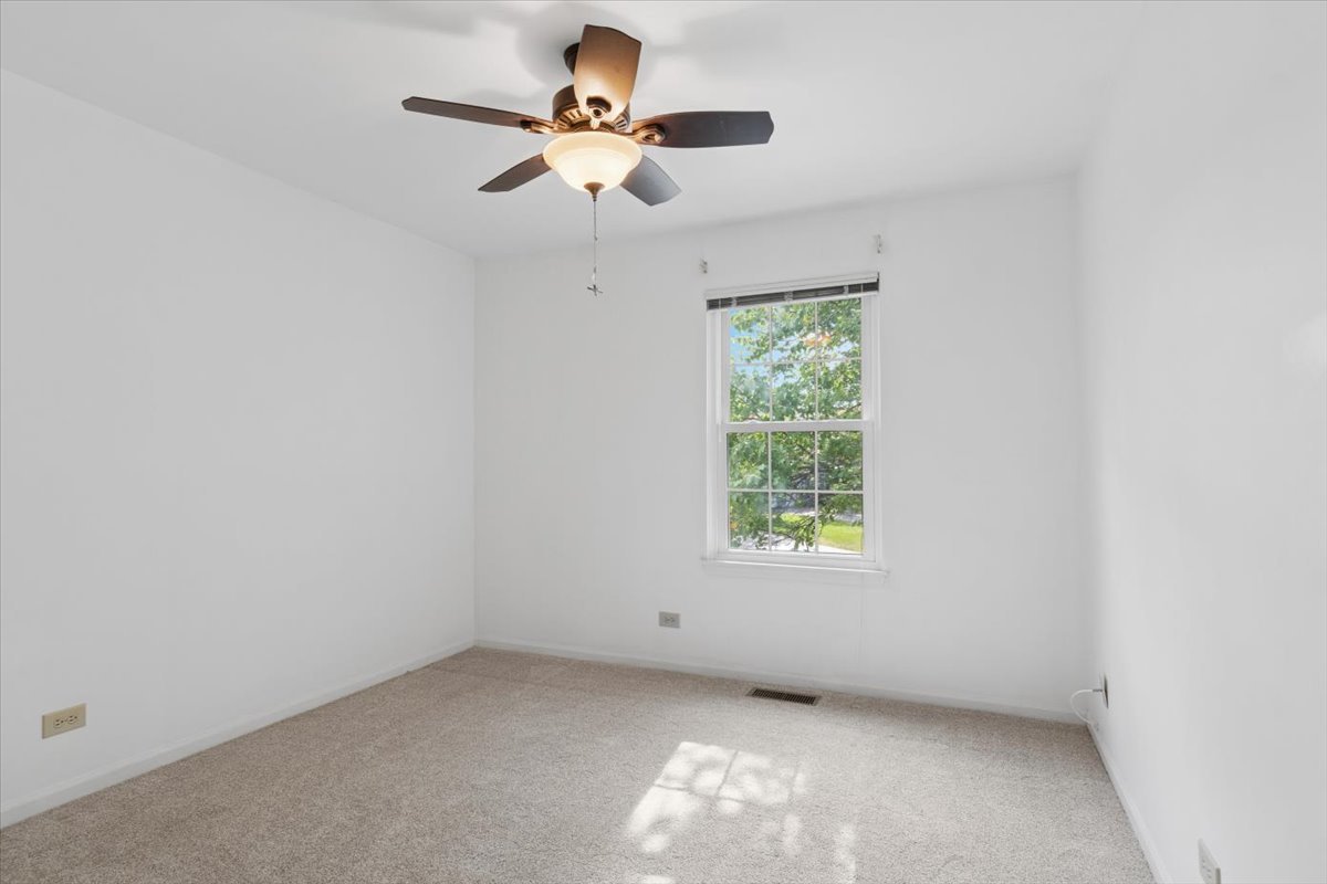 305 Cane Garden Circle, Unit 305 Aurora, IL 60504 - Photo 8 of 20 an empty room with a window and a fan