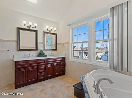 a bathroom with a bathtub sink and mirror