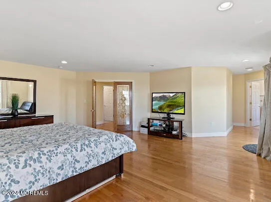 a bedroom with a bed and wooden floor