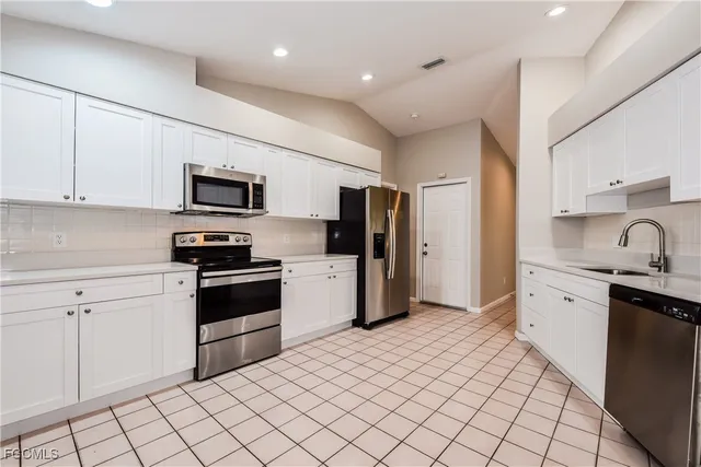 a kitchen with stainless steel appliances a refrigerator sink and microwave