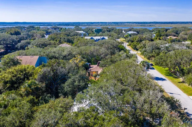 an aerial view of a houses with a yard and lake view