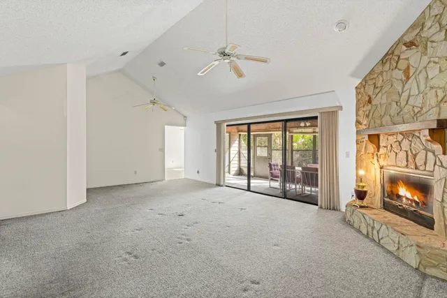 a view of an empty room with a fireplace and a window