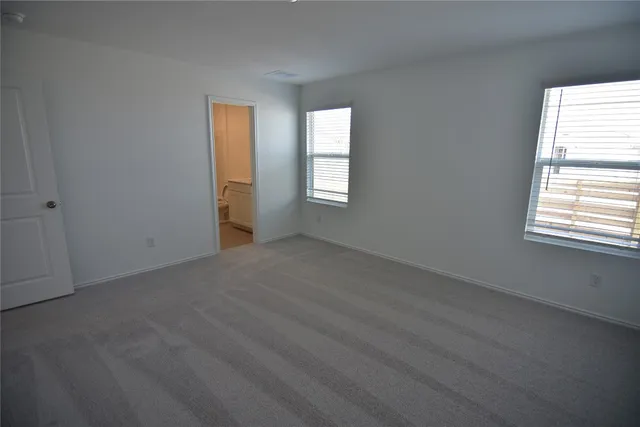 an empty room with windows and mirror