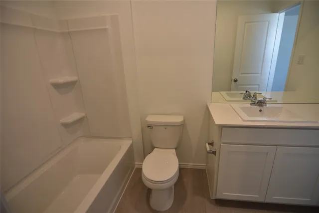 a bathroom with a toilet a sink a vanity and mirror