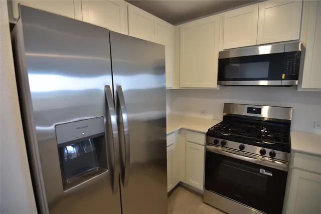 a kitchen with stainless steel appliances granite countertop a stove a sink and a refrigerator