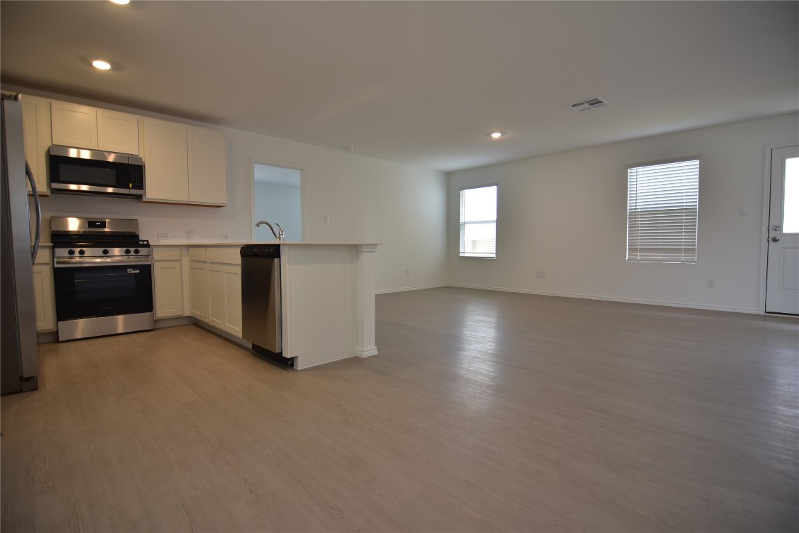 373 Keefer Kyle, TX 78640 - Photo 35 of 39 a kitchen with stainless steel appliances granite countertop a stove a sink and a refrigerator
