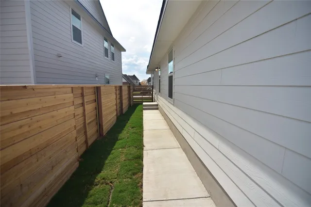 a backyard of a house with wooden fence and a yard
