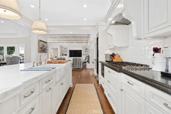 a large kitchen with stainless steel appliances granite countertop a stove and a view of living room