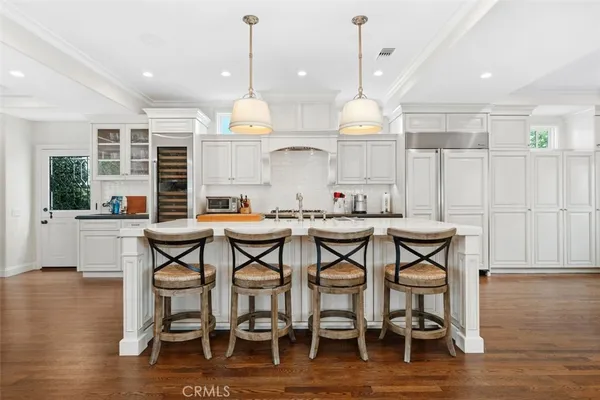 a kitchen with a dining table chairs sink and cabinets