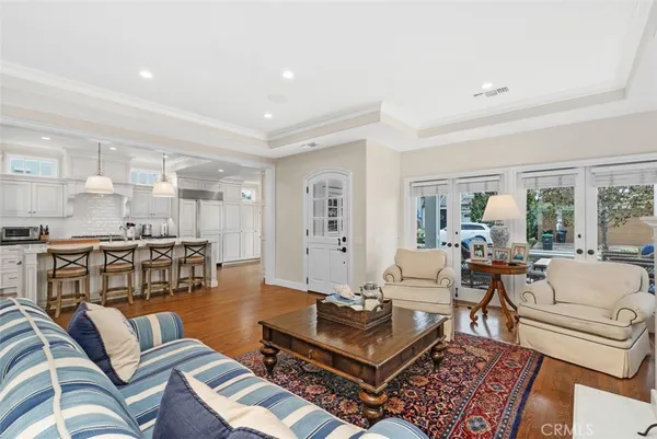 a living room with furniture kitchen view and large windows