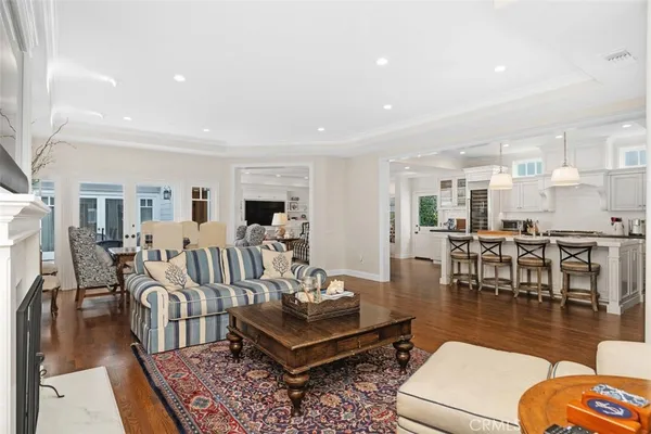 a living room with lots of furniture and a dining table with wooden floor