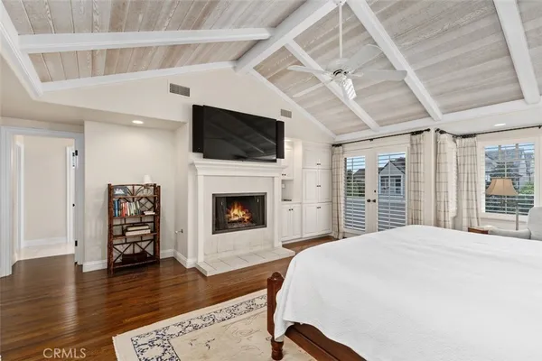a spacious bedroom with a bed and a flat screen tv