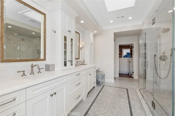 a bathroom with a double vanity sink mirror and shower