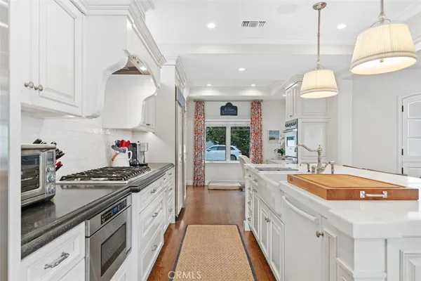 a kitchen with granite countertop a sink stove and cabinets