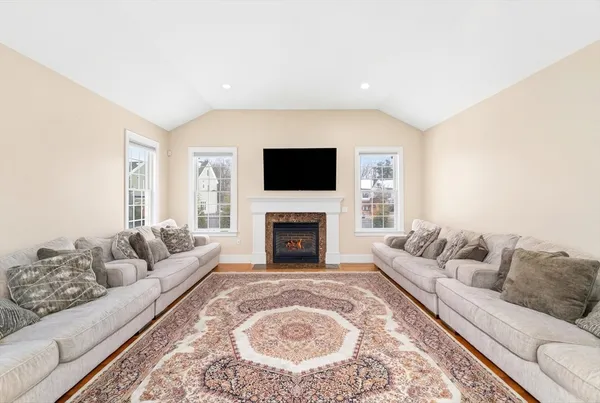 a living room with furniture a flat screen tv and a fireplace