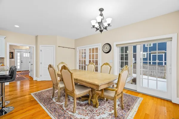 a view of a dining room with furniture a chandelier and wooden floor
