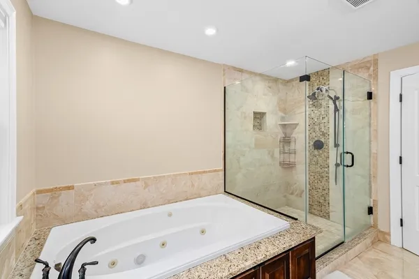 a bathroom with a granite countertop bathtub shower and sink