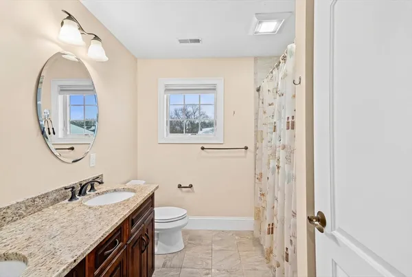 a bathroom with a granite countertop sink toilet and shower